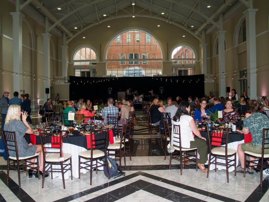 A group of people sitting at tables in a room</p>
<p>AI-generated content may be incorrect., Picture